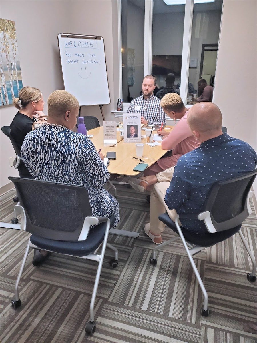 A team meeting around the boardroom table at Ensemble Coworking