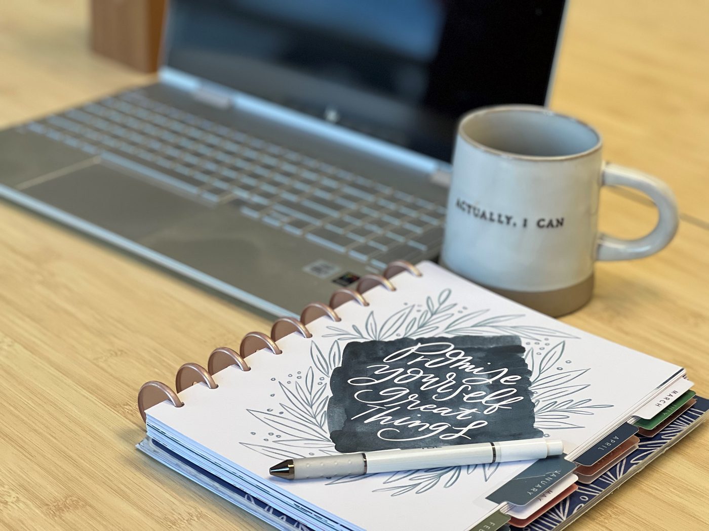 Working from a laptop with a coffee mug and notebook